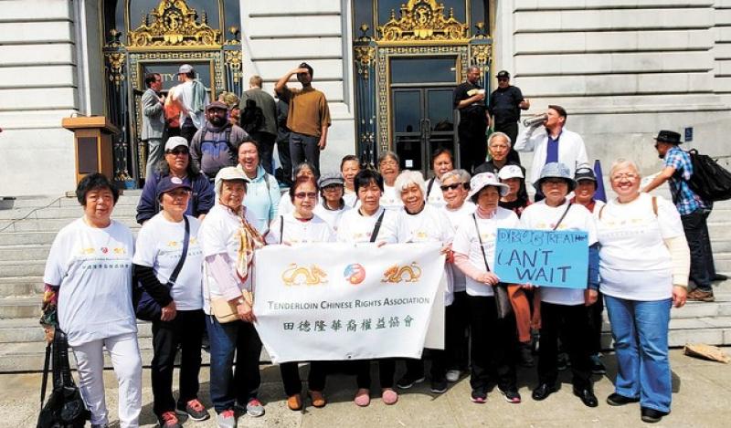 A group of people stand outside City Hall with a Chinese Rights Association sign