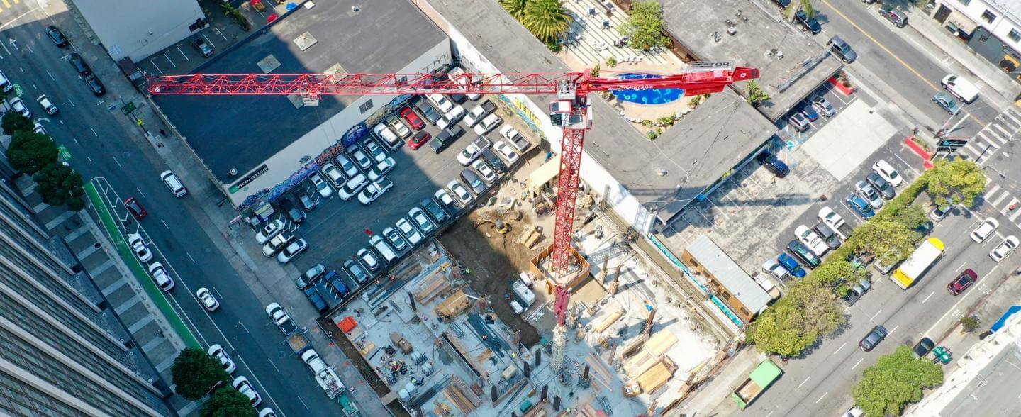 Aerial view of construction at 555 Larkin in the Tenderloin, a red crane is pictured at the center