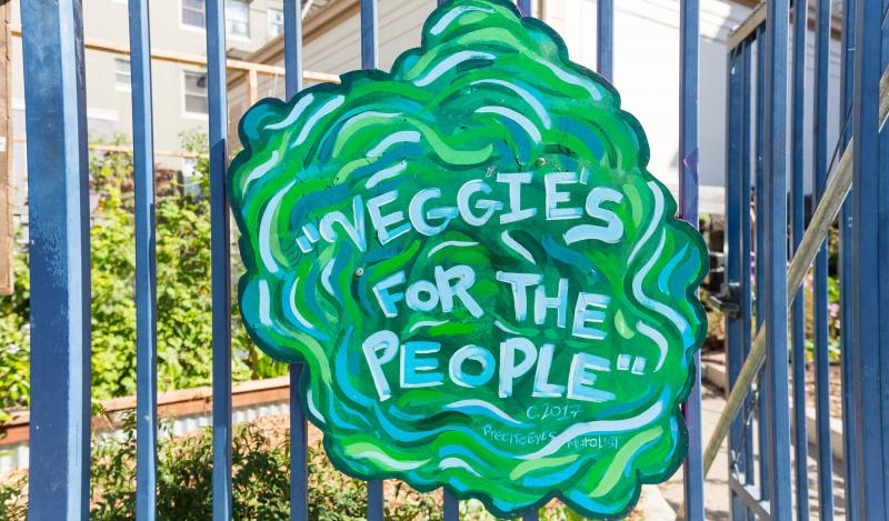 A sign shaped like lettuce reads "Veggies for the people"