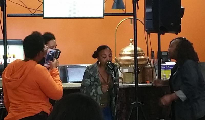 Several black women perform karaoke 
