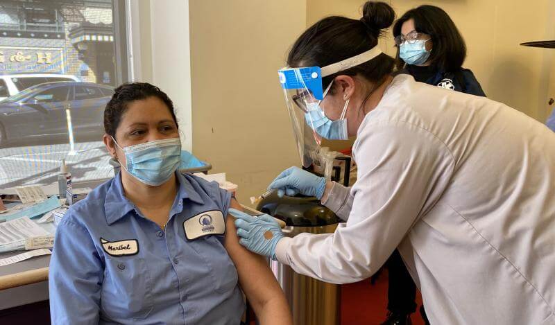 A TNDC custodian gets vaccinated at Antonia Manor