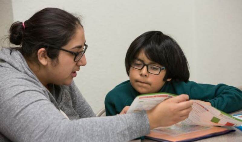 a TASP worker helps a young child with their homework