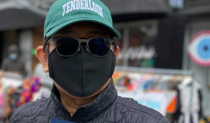 Lorenzo Listana wears a face mask and poses with a Certificate of Honor