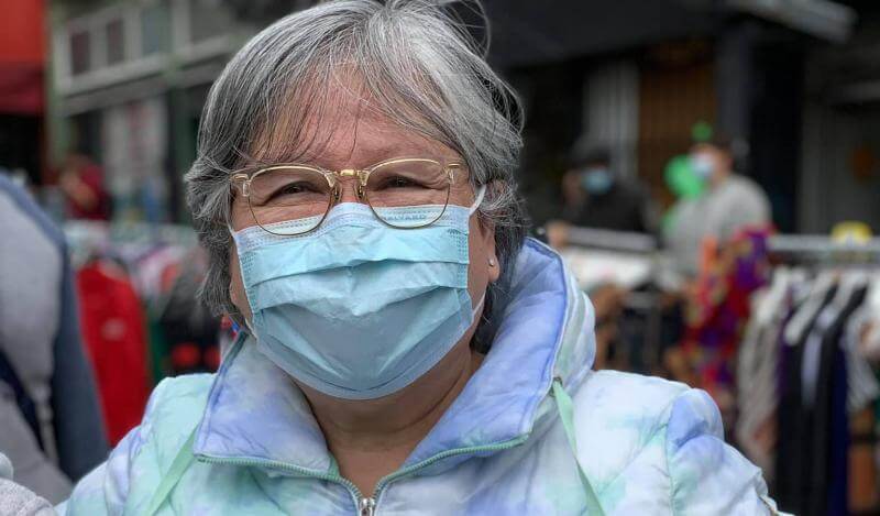 Siu Cheung wears a face mask and poses with a Certificate of Honor