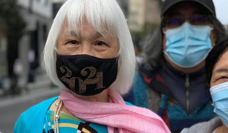 Tammy wears a face mask and poses with a Certificate of Honor