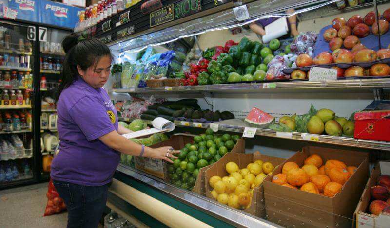 A resident inspects produce at a corner store