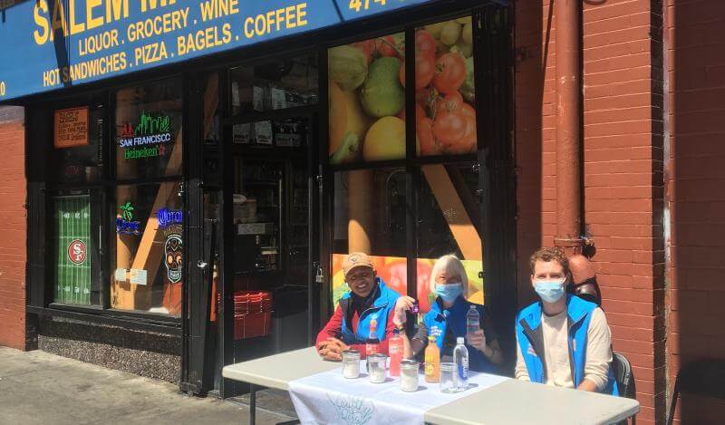 people sitting at a table on a sidewalk