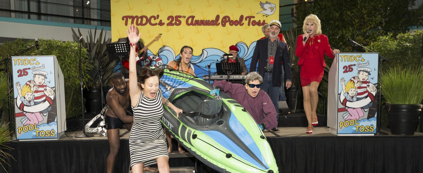 Two women jump with an inflatable kayak into a pool