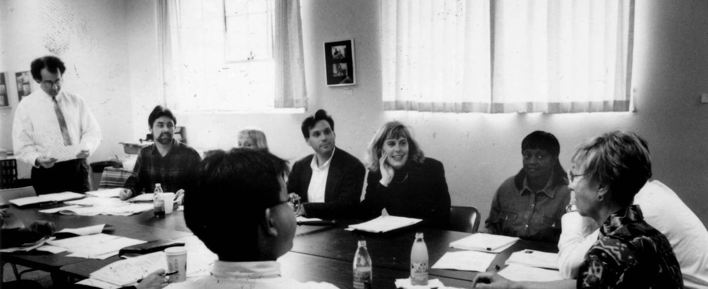 a black and white photo of a board meeting