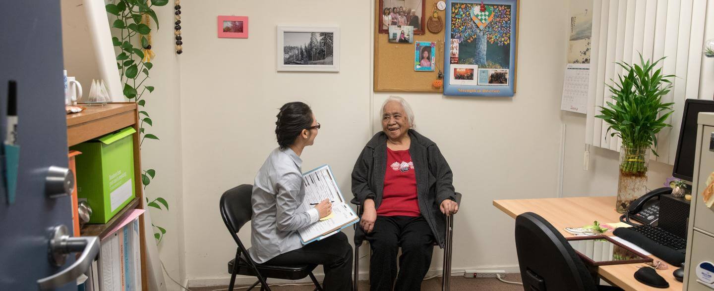 An asian social worker assists a tenant in her office