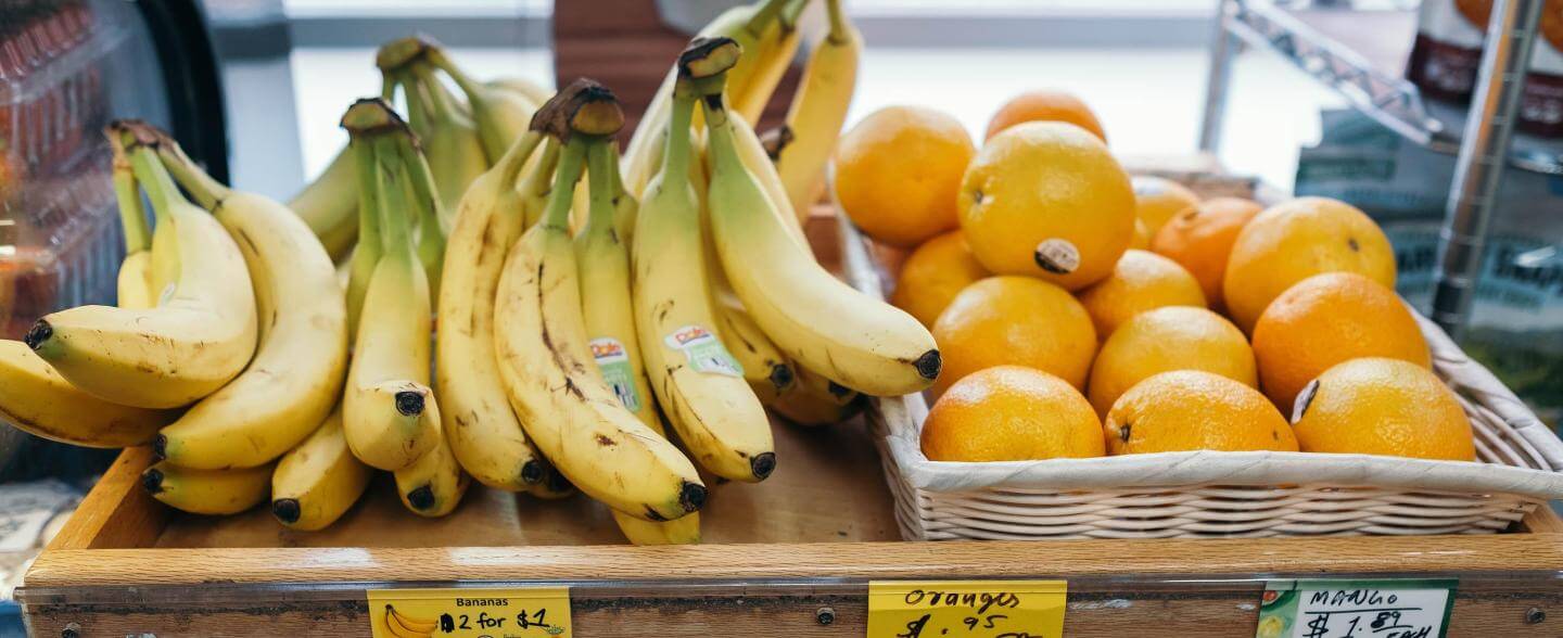 Bananas and oranges on a shelf