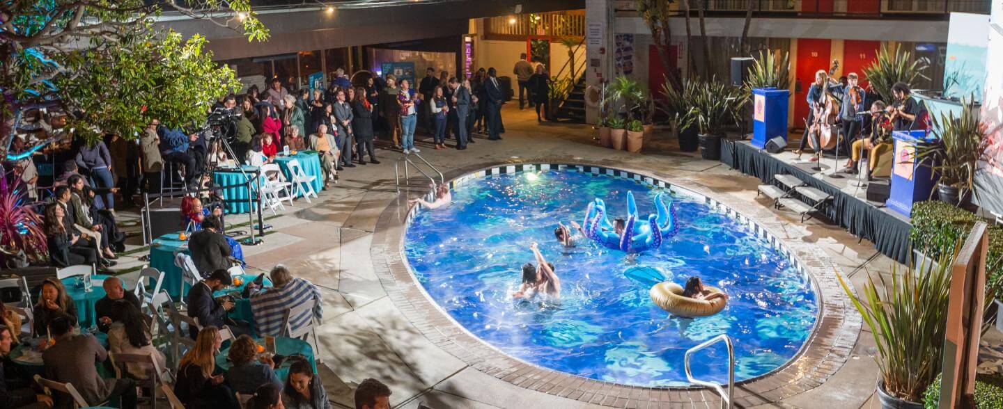 Banner of a pool with plants and people around 