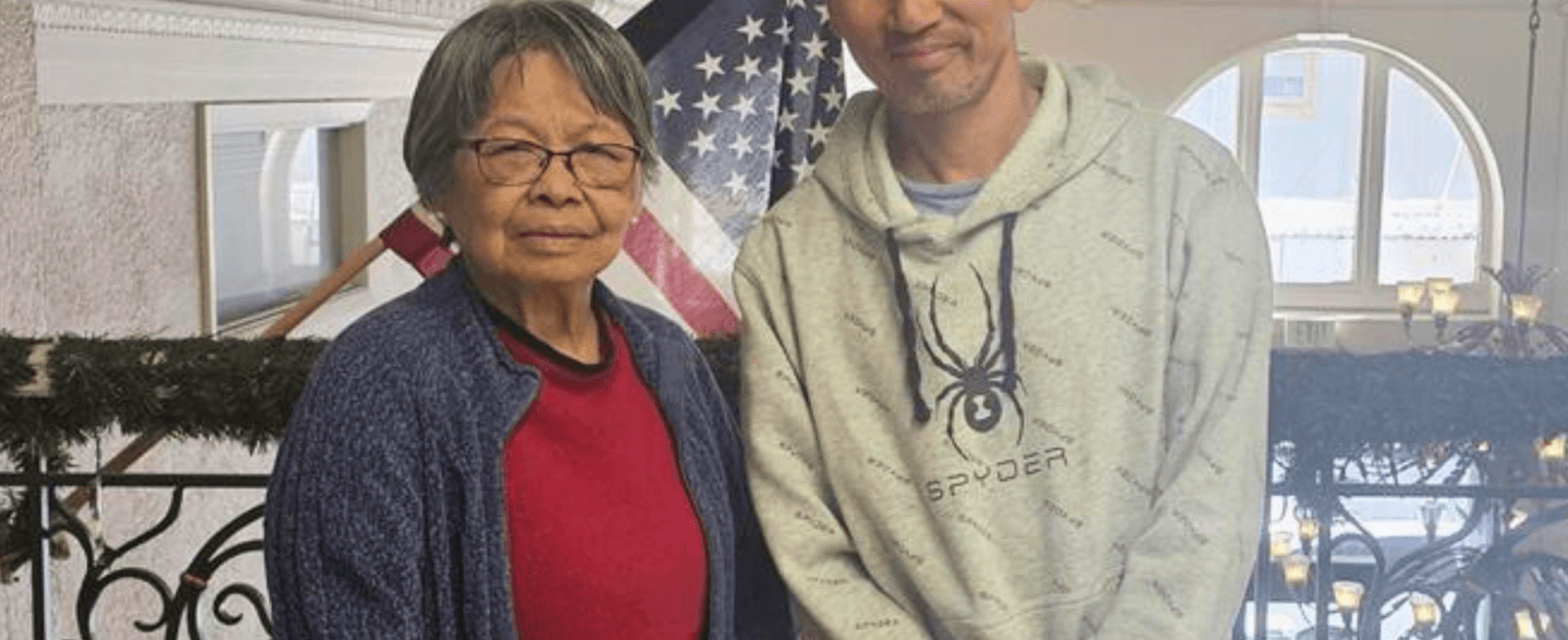 Paul and betty pose in front of american flag