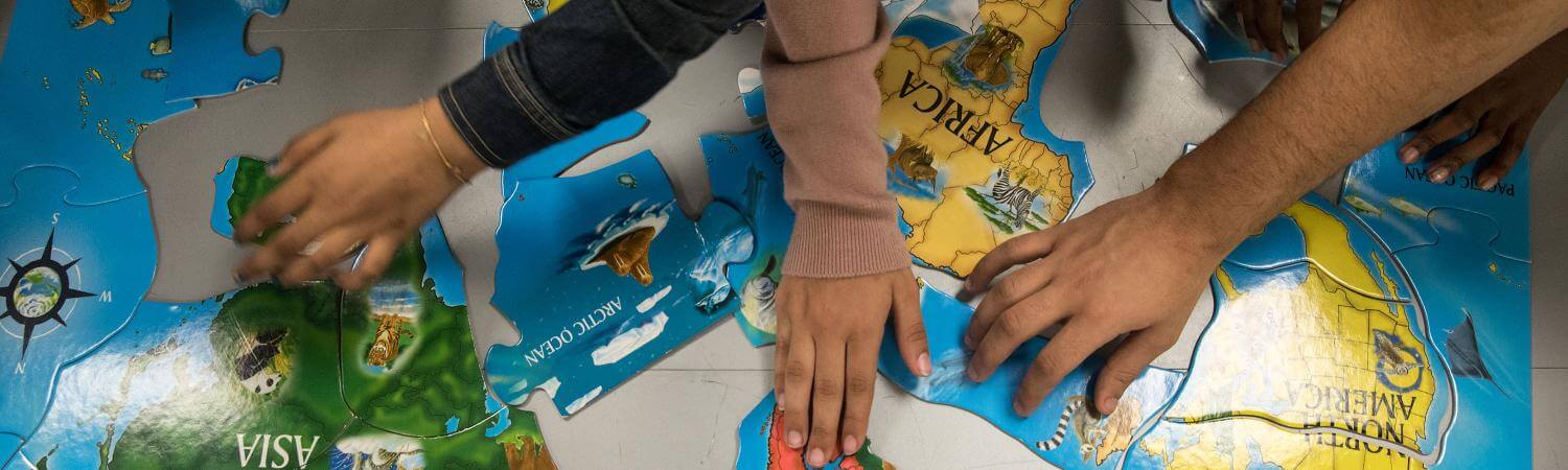 Pairs of hands put together a world map