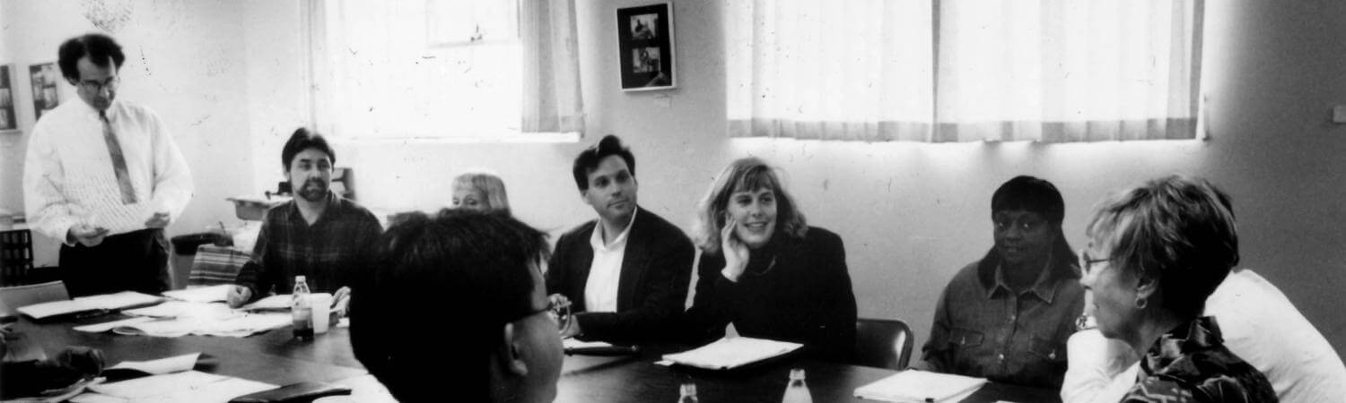 a black and white photo of a board meeting