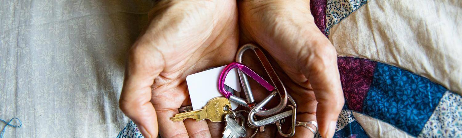 Hands cradle colorful keys above a quilt pattern