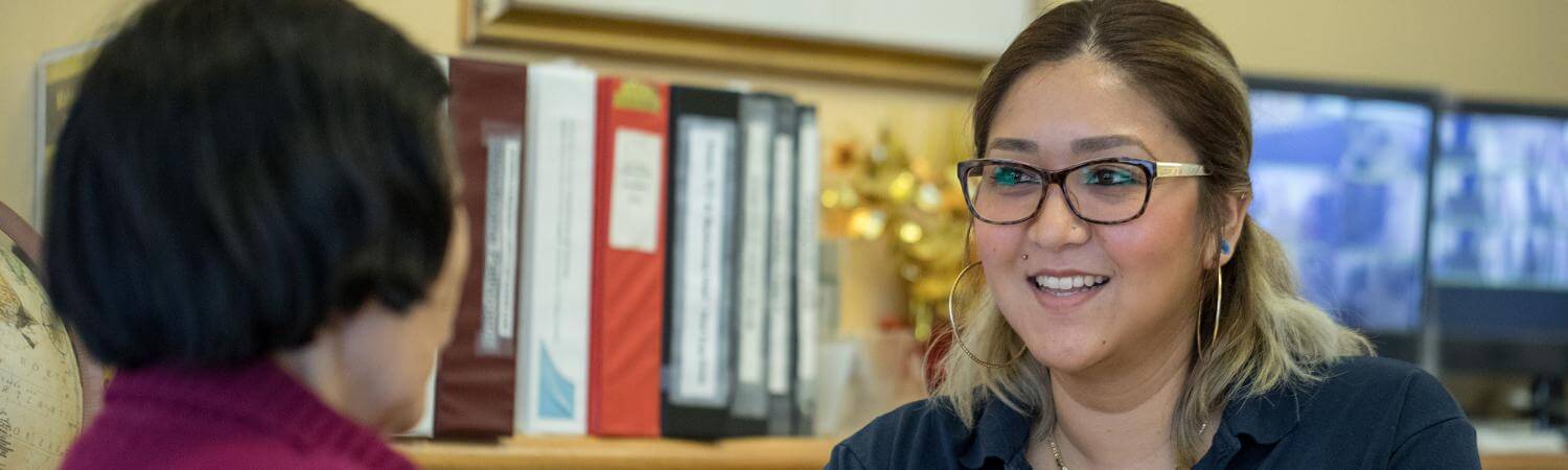 A woman helps a senior at the front desk