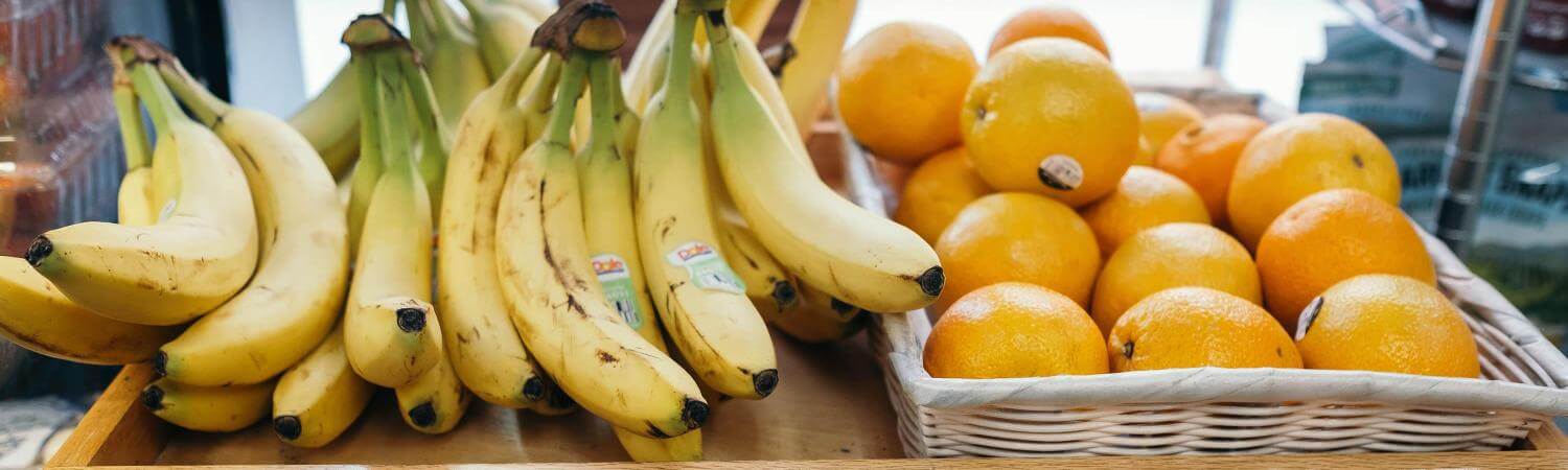 Bananas and oranges on a shelf