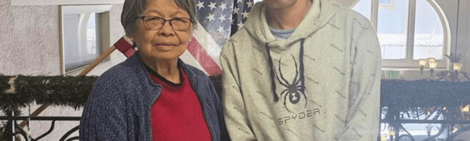 Paul and betty pose in front of american flag