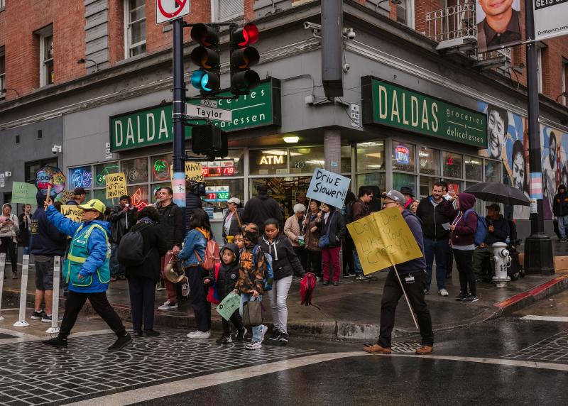 A group of community members hold up signs in protest on Eddy and Taylor Street