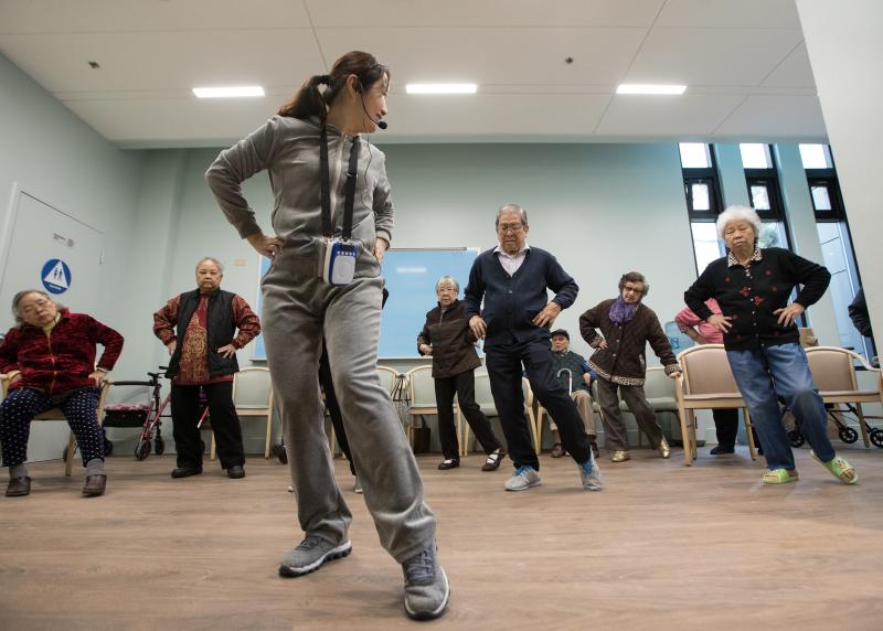 A group of Asian seniors practice Tai Chi 