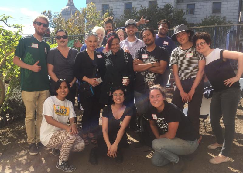 A multi-racial group gathers together for a photo in a garden