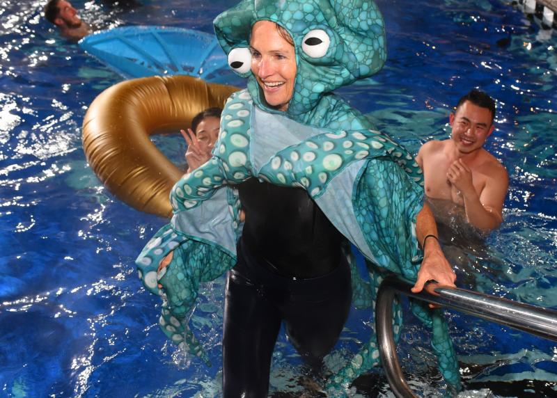 A woman dresses like an octopus gets out of a pool