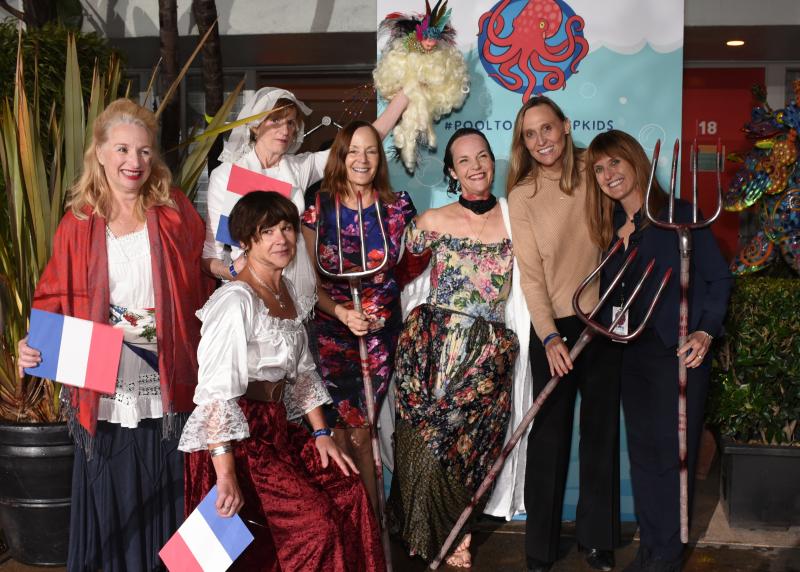 A group of people dressed up in old-style French outfits pose