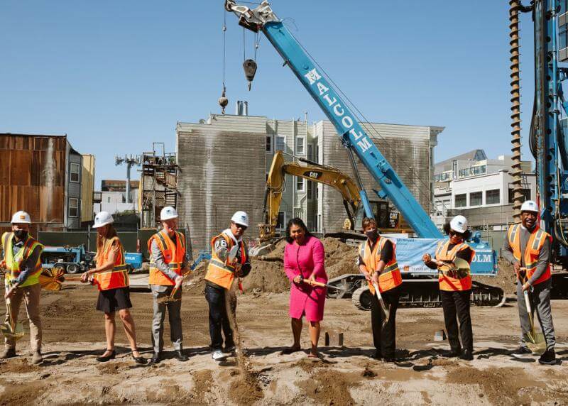 a group including Mayor Breed shovel dirt at the 921 Howard construction site