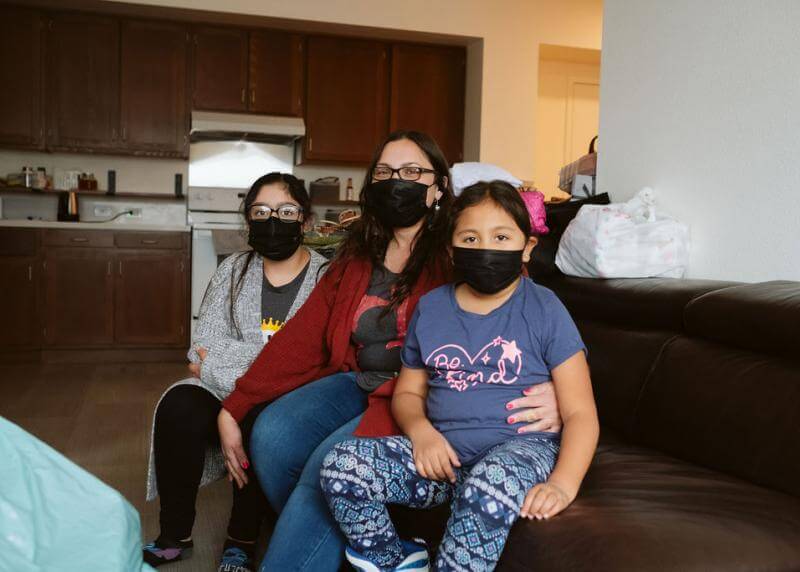 mother and two daughters on a couch