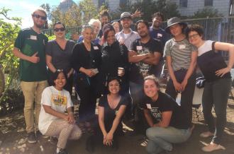 A multi-racial group stand together in a garden