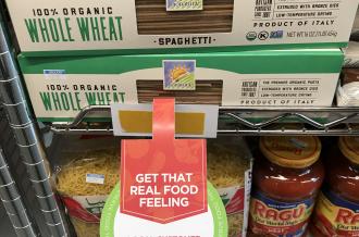 A box of whole wheat pasta with a tag reading "local customer discount item"