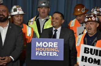 Person at podium surrounded by people in hard hats