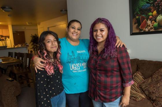 three people standing in livingroom